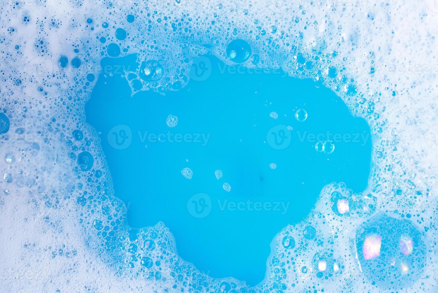 Close-up image of blue water with soap bubbles forming on the surface, perfect for cleaning, hygiene, and background projects. photo