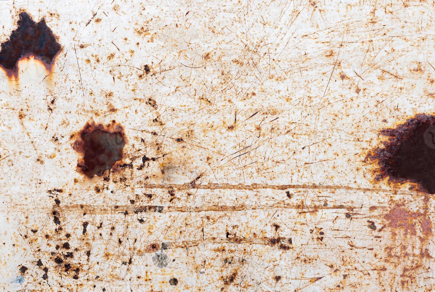 Rust-stained metal surface with scratches and weathered texture, perfect for backgrounds or industrial themes. photo