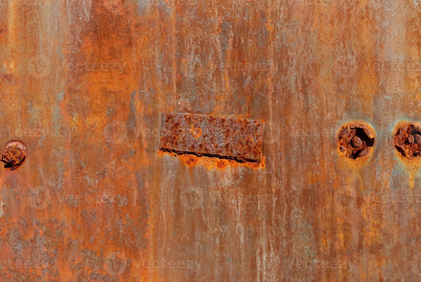 Close-up of rusty metal texture with natural corrosion patterns and vivid orange-brown tones, perfect for backgrounds and industrial-themed designs. photo