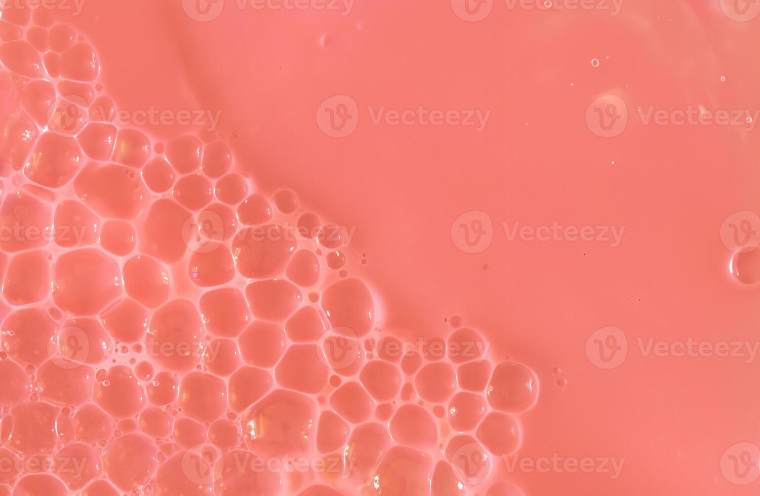 Close-up image of pink liquid with delicate bubbles forming on the surface, ideal for backgrounds, cosmetic, or science-related designs. photo