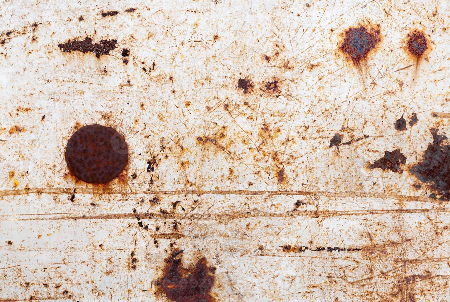 Rust-stained metal surface with scratches and weathered texture, perfect for backgrounds or industrial themes. photo