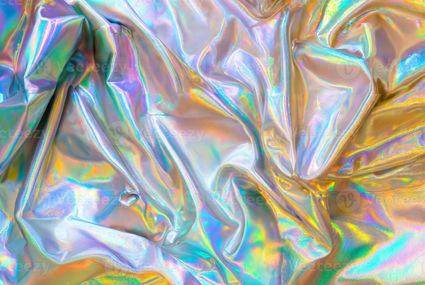 Close-up of iridescent holographic fabric with vibrant rainbow-like colors reflecting off the material, creating a futuristic and colorful texture photo