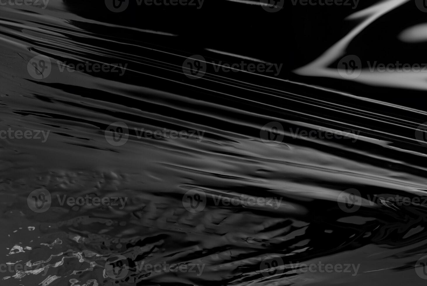 Close-up of abstract black glossy plastic texture with smooth, reflective surface, perfect for backgrounds or design concepts photo