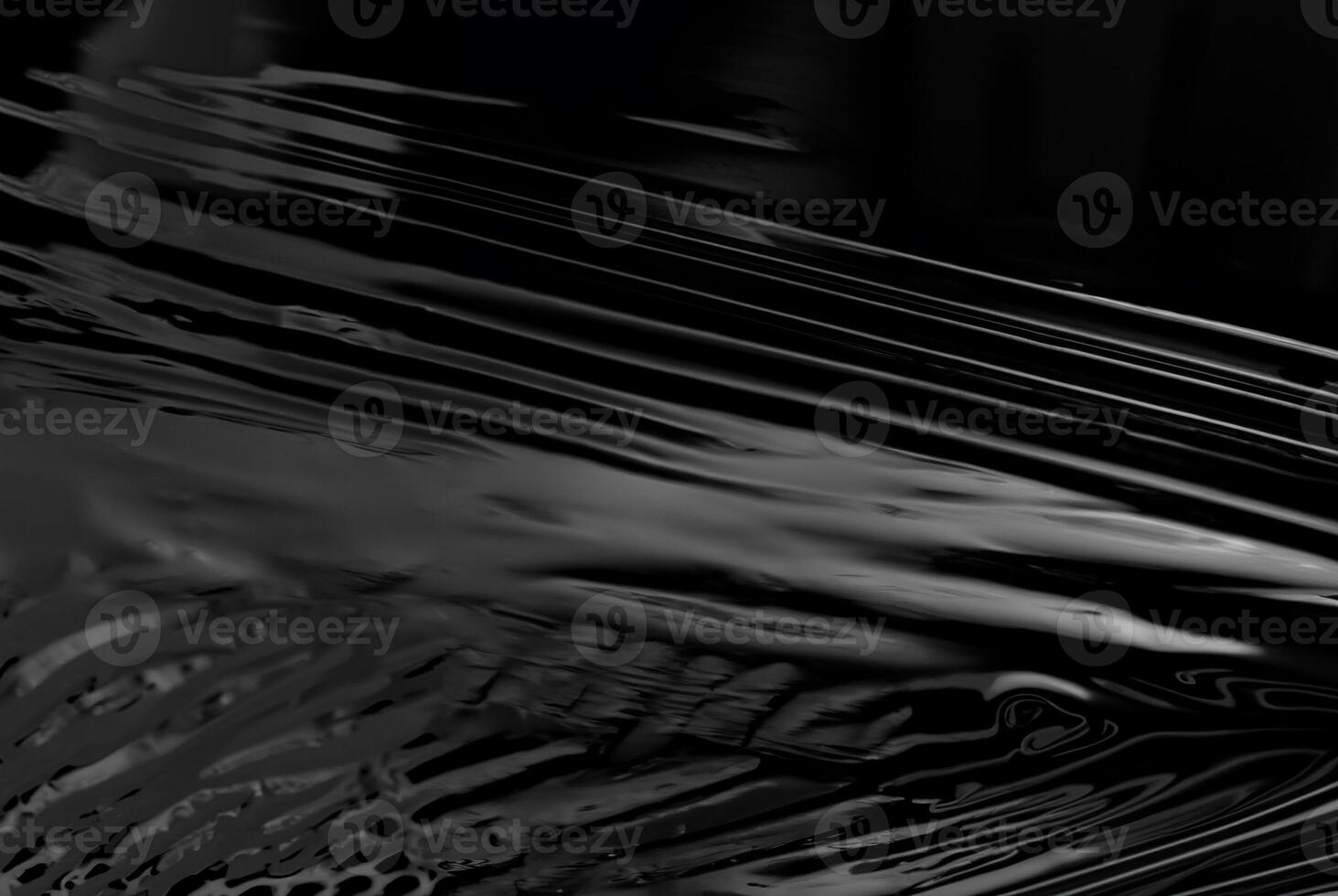 Close-up of abstract black glossy plastic texture with smooth, reflective surface, perfect for backgrounds or design concepts photo