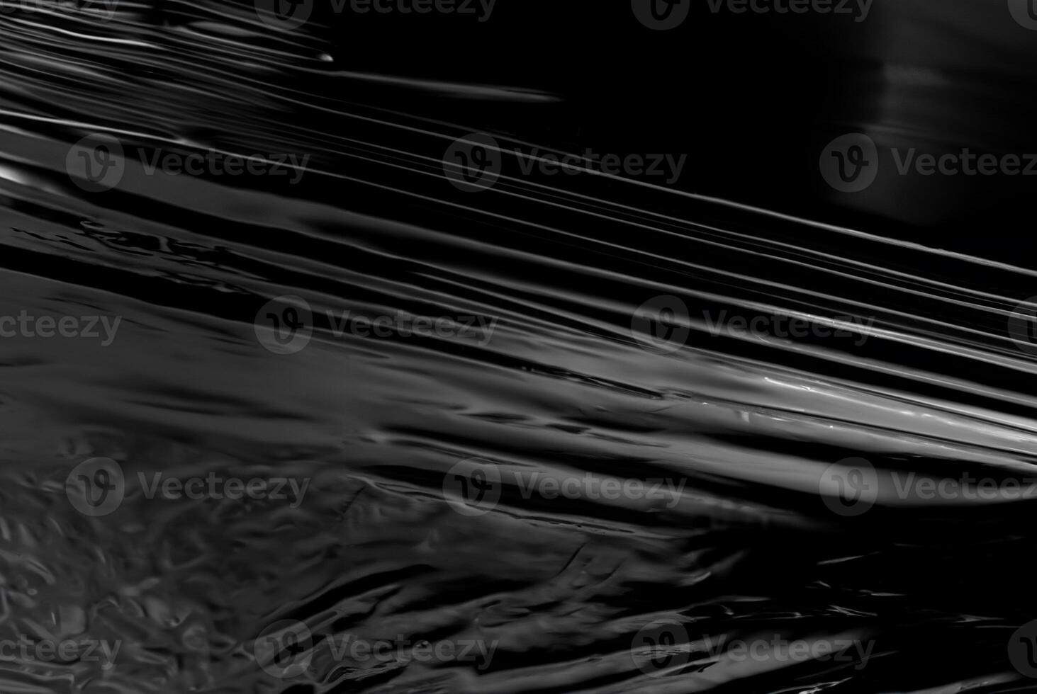 Close-up of abstract black glossy plastic texture with smooth, reflective surface, perfect for backgrounds or design concepts photo