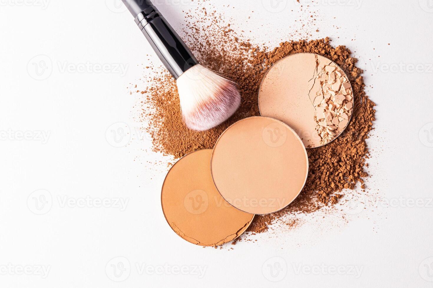 A top view of three blocks of compact powder in different tones and a delicate brush for makeup. white background. Layout for product presentation photo
