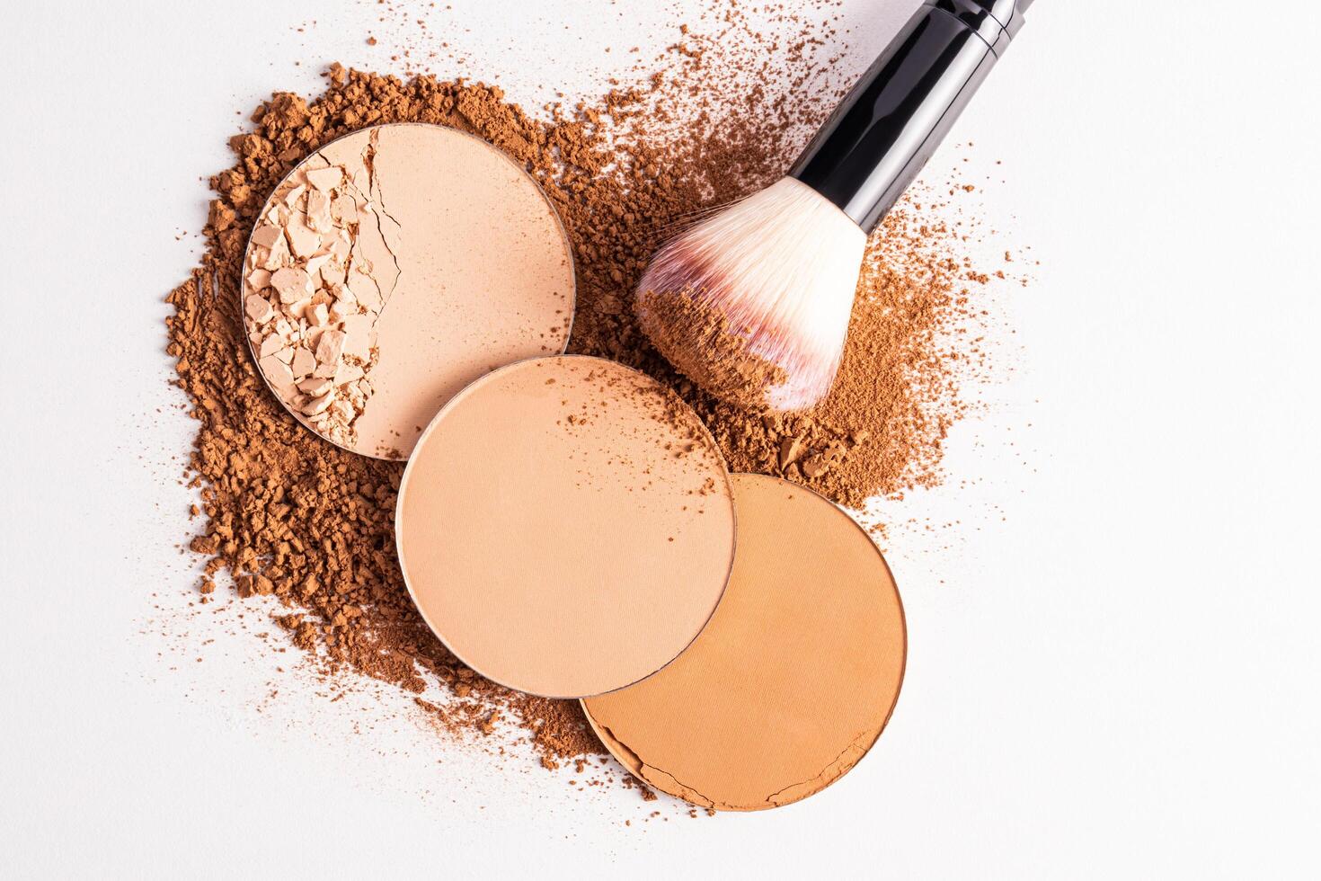 several loose round block powder and makeup brush, applying powder on face on white background. Concept of cosmetics , makeup. Top view photo