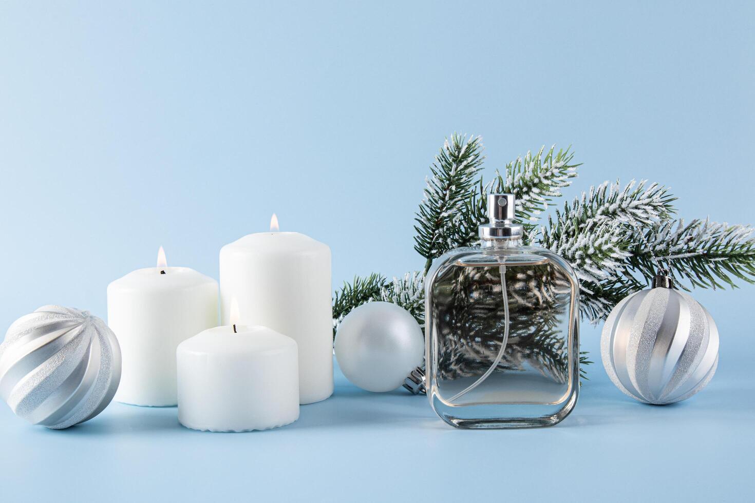 New Year's festive composition with a bottle of perfume. a spruce branch, candles, silver Christmas balls . unbranded bottle of perfume. template. photo