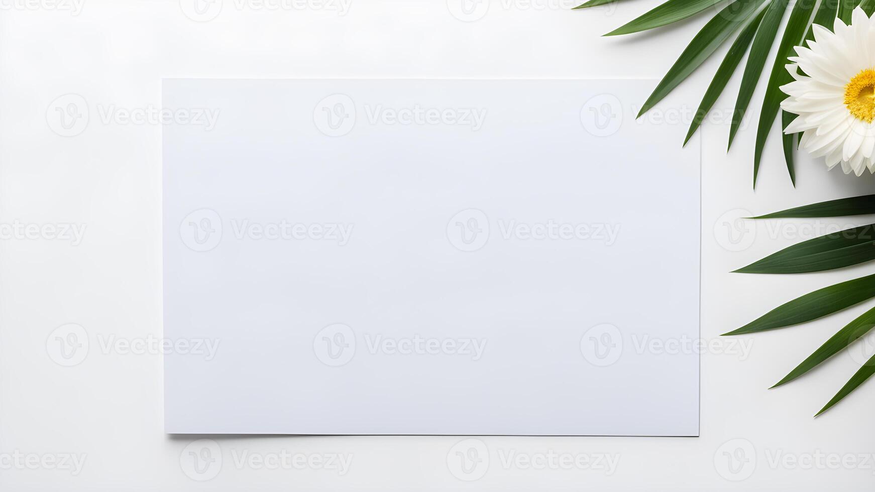 Top view blank space white rectangle paper mock up adorned by white flower and tropical plant leaf on white table for creative design photo