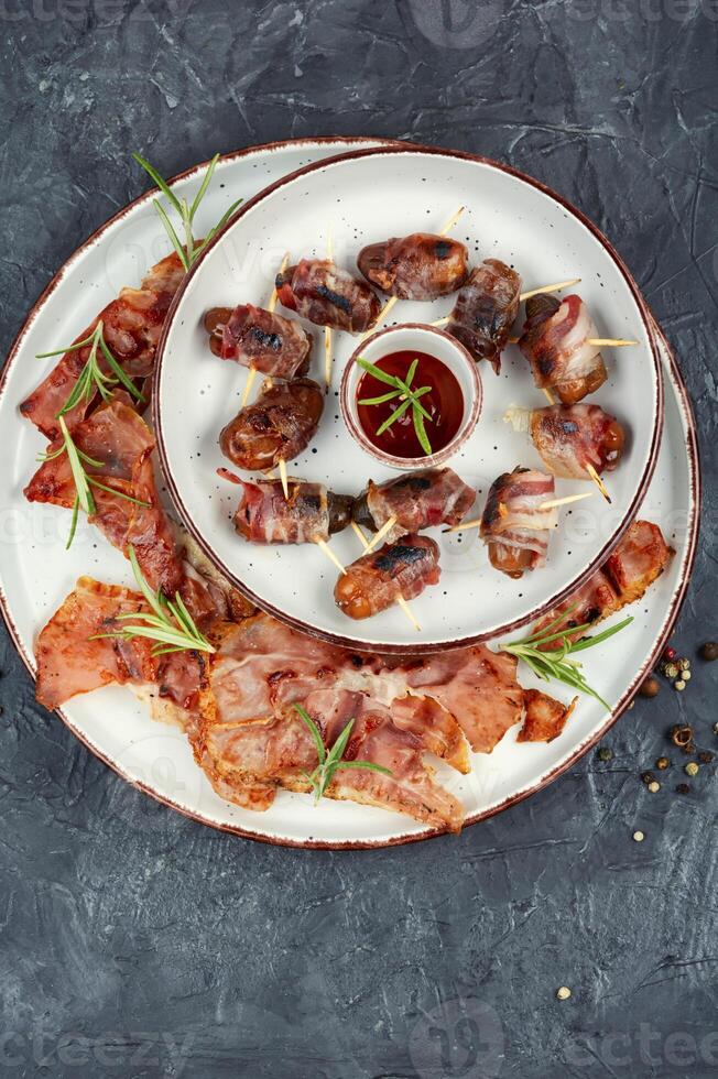 A plate of bacon wrapped dates. photo