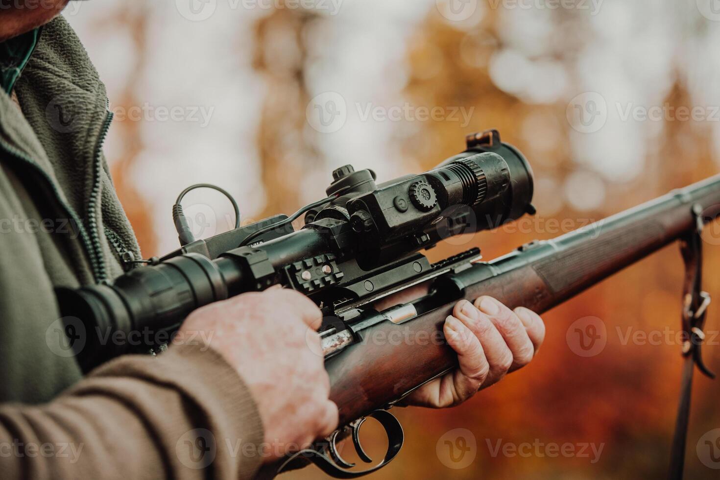 Portrait of hunter or ranger with gun or rifle in a forest looking out or hunting of some venison, hunting period, autumn season, hunting and people concept photo