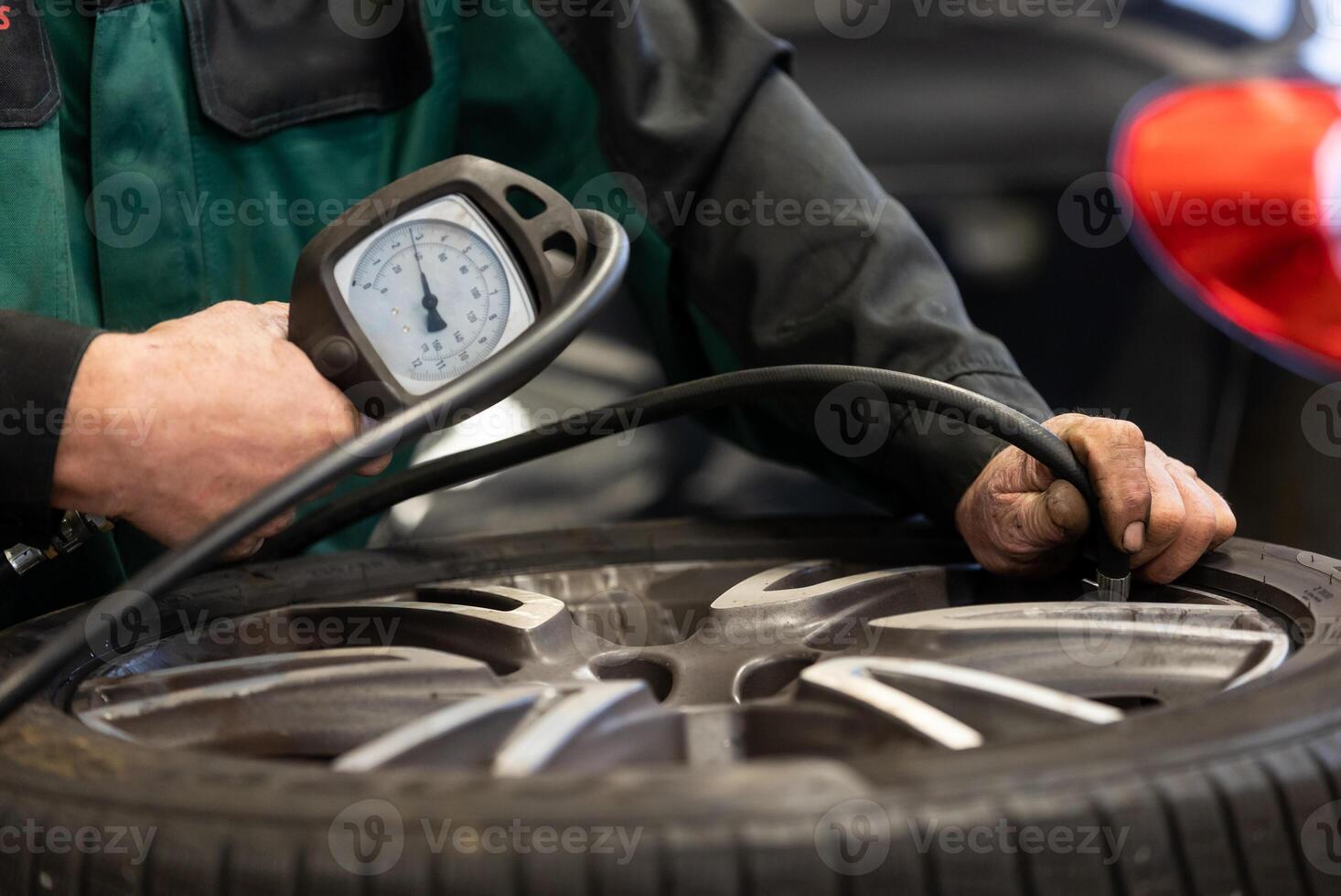 Car mechanic working in garage and changing wheel alloy tires, repair and maintenance auto service, vehicle service concept photo