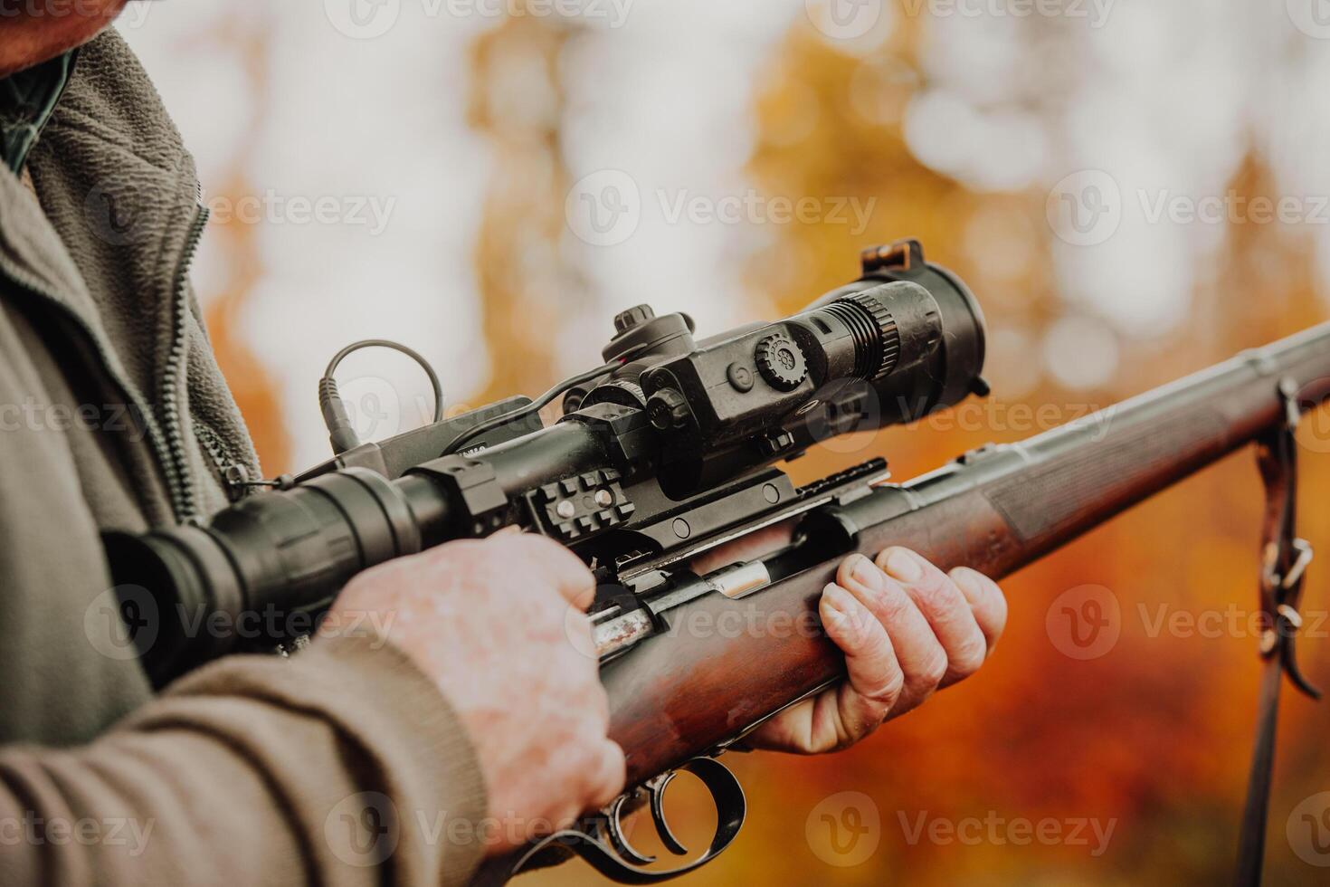 Portrait of hunter or ranger with gun or rifle in a forest looking out or hunting of some venison, hunting period, autumn season, hunting and people concept photo
