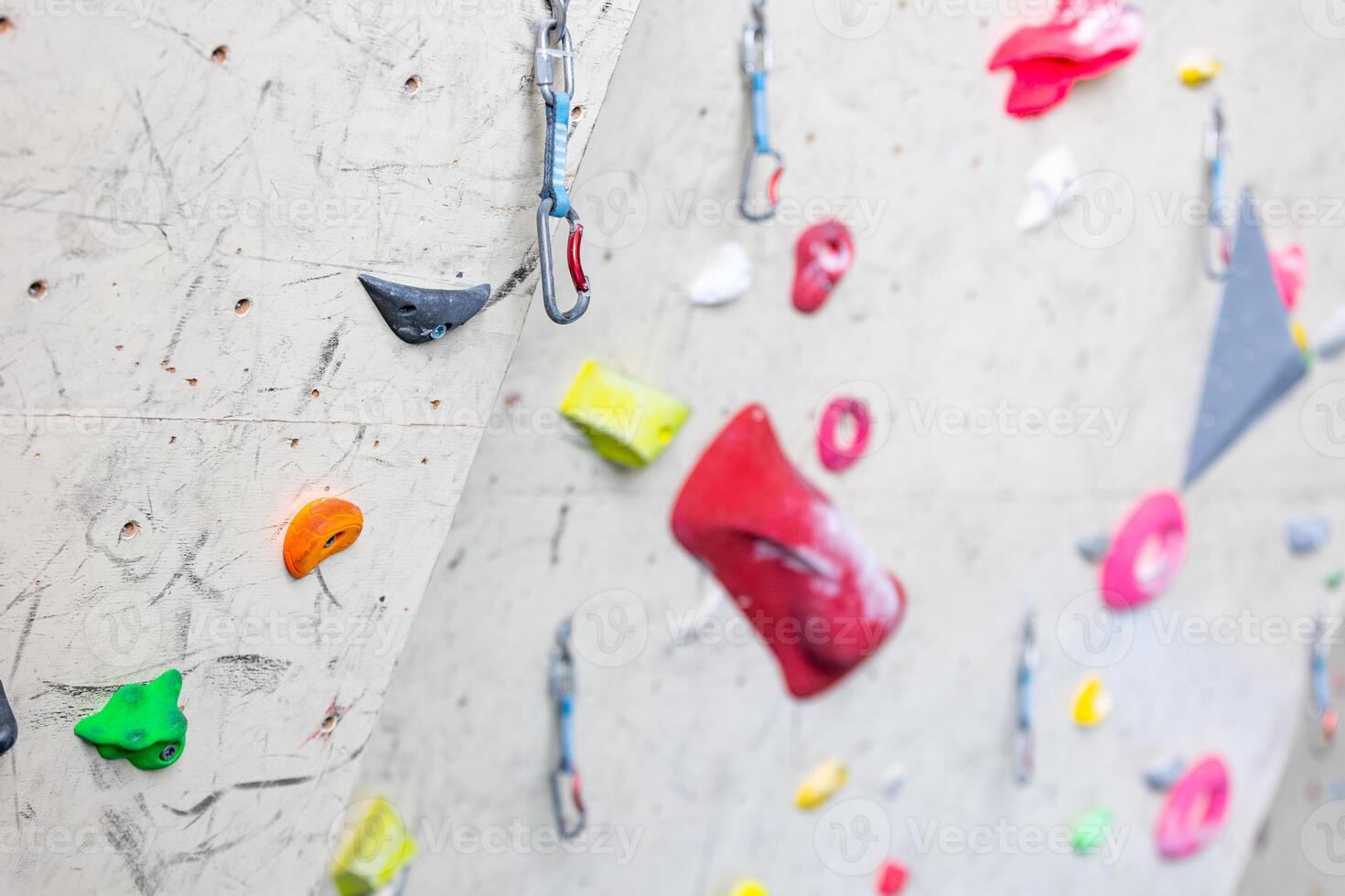 Close up of colorful hooks or grips with carbines for the climbing wall photo