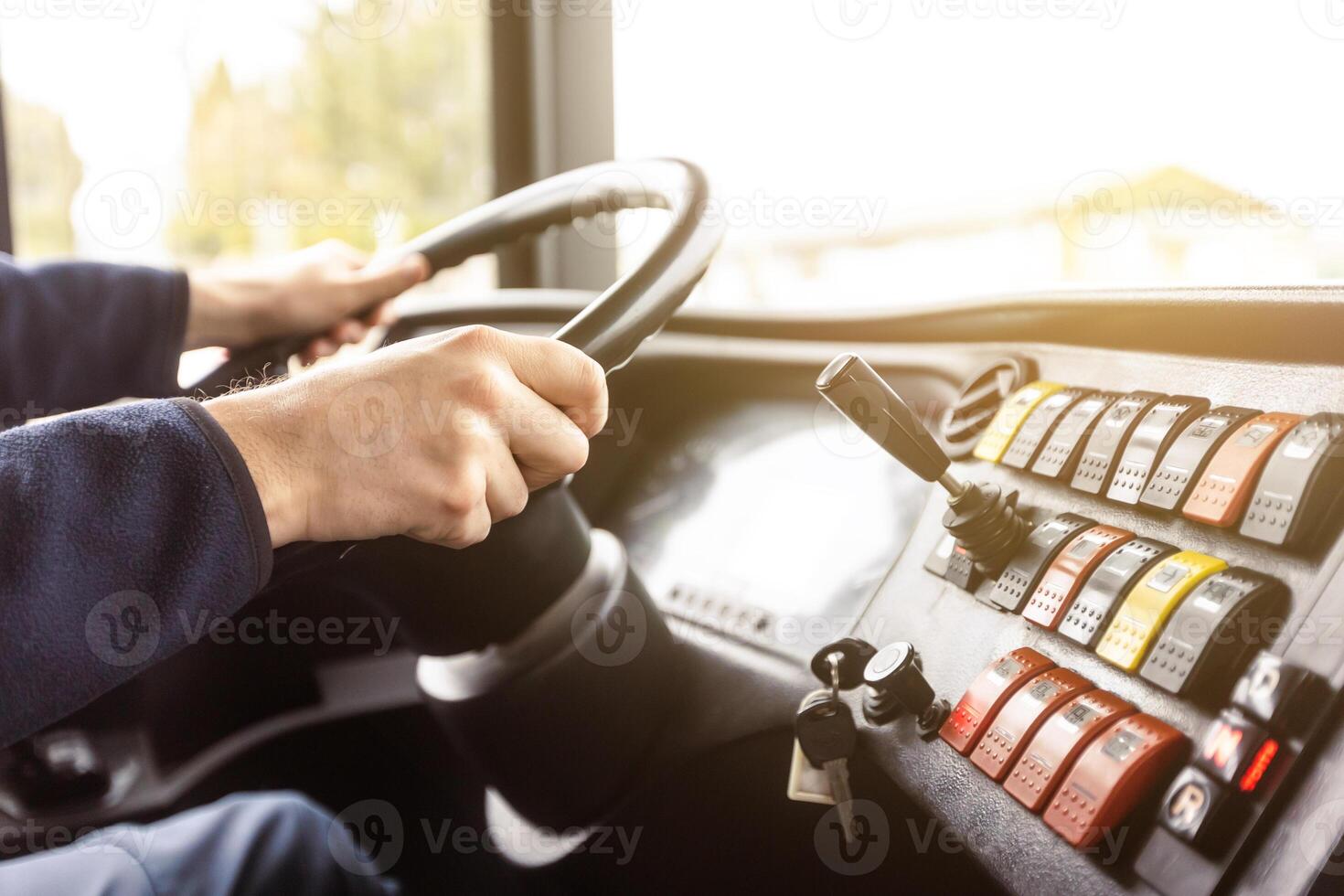 Hands of the driver in a modern bus according to the ride, detail of the bus drivers steering wheel and driving a passenger bus, transportation concept photo