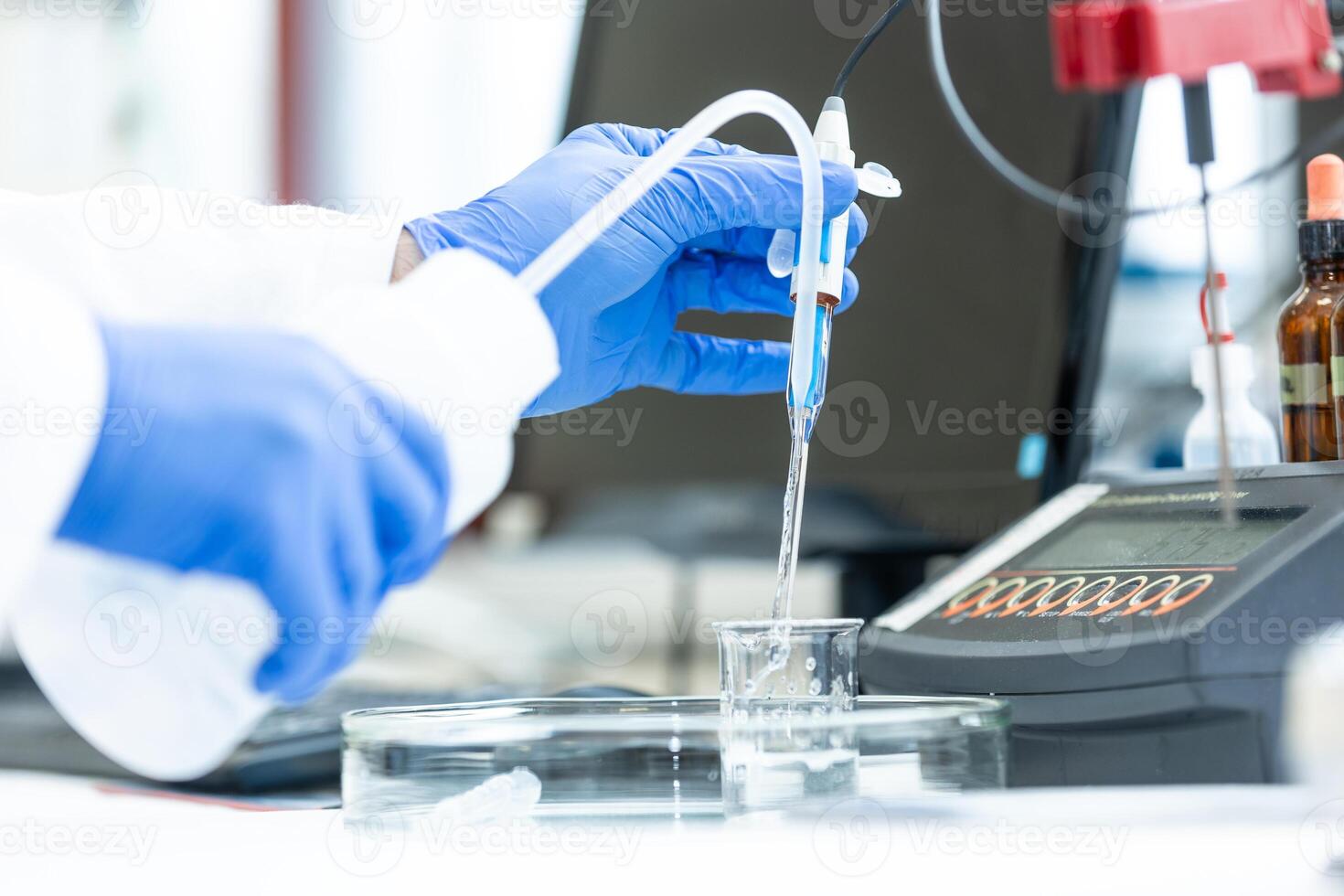 Laboratory technician holding glass electrode for measuring of pH of the solution using pH meter., analytical or electro chemistry laboratory, lab concept photo