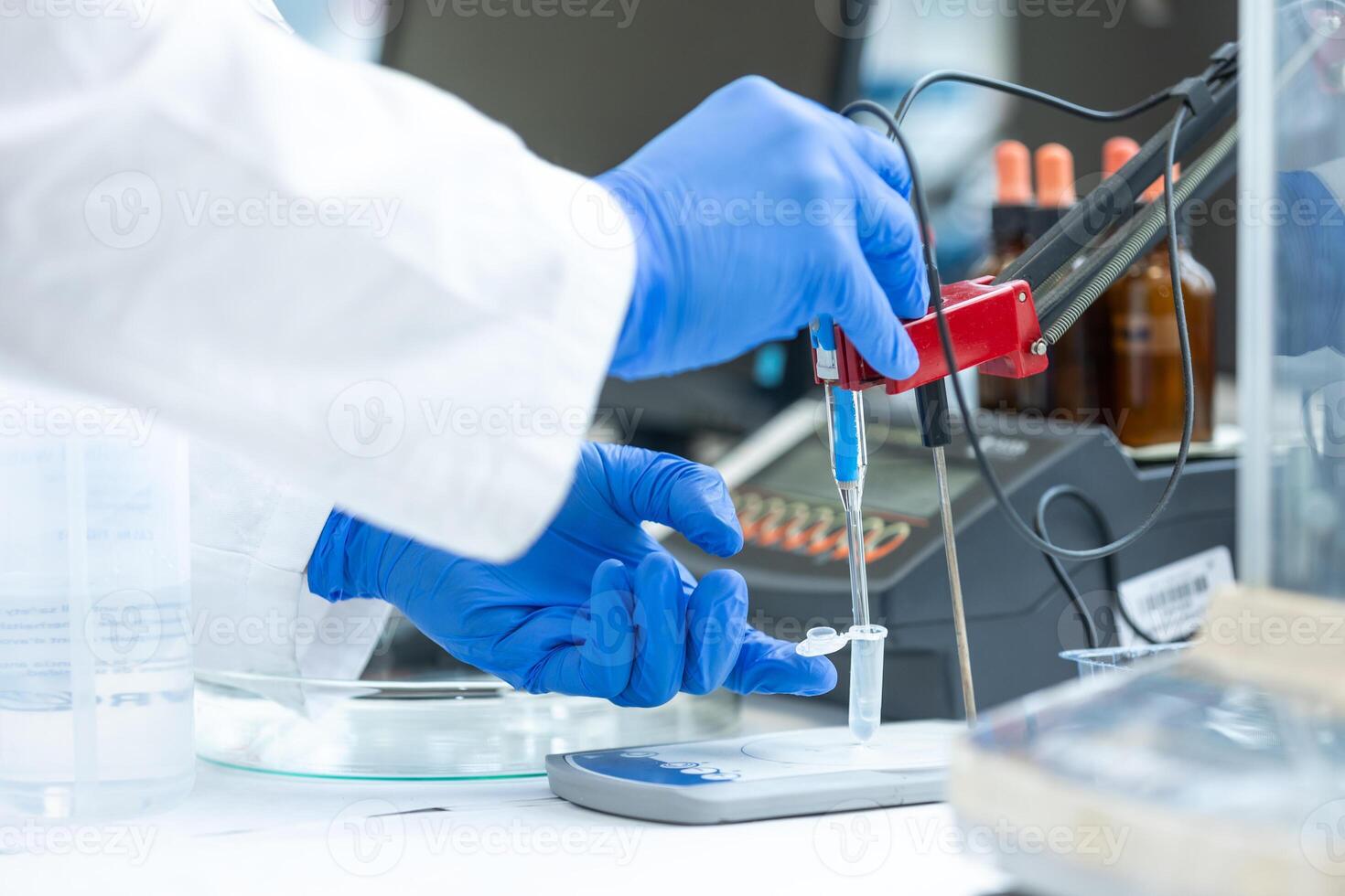 Laboratory technician holding glass electrode for measuring of pH of the solution using a pH meter., analytical or electro chemistry laboratory, lab concept photo