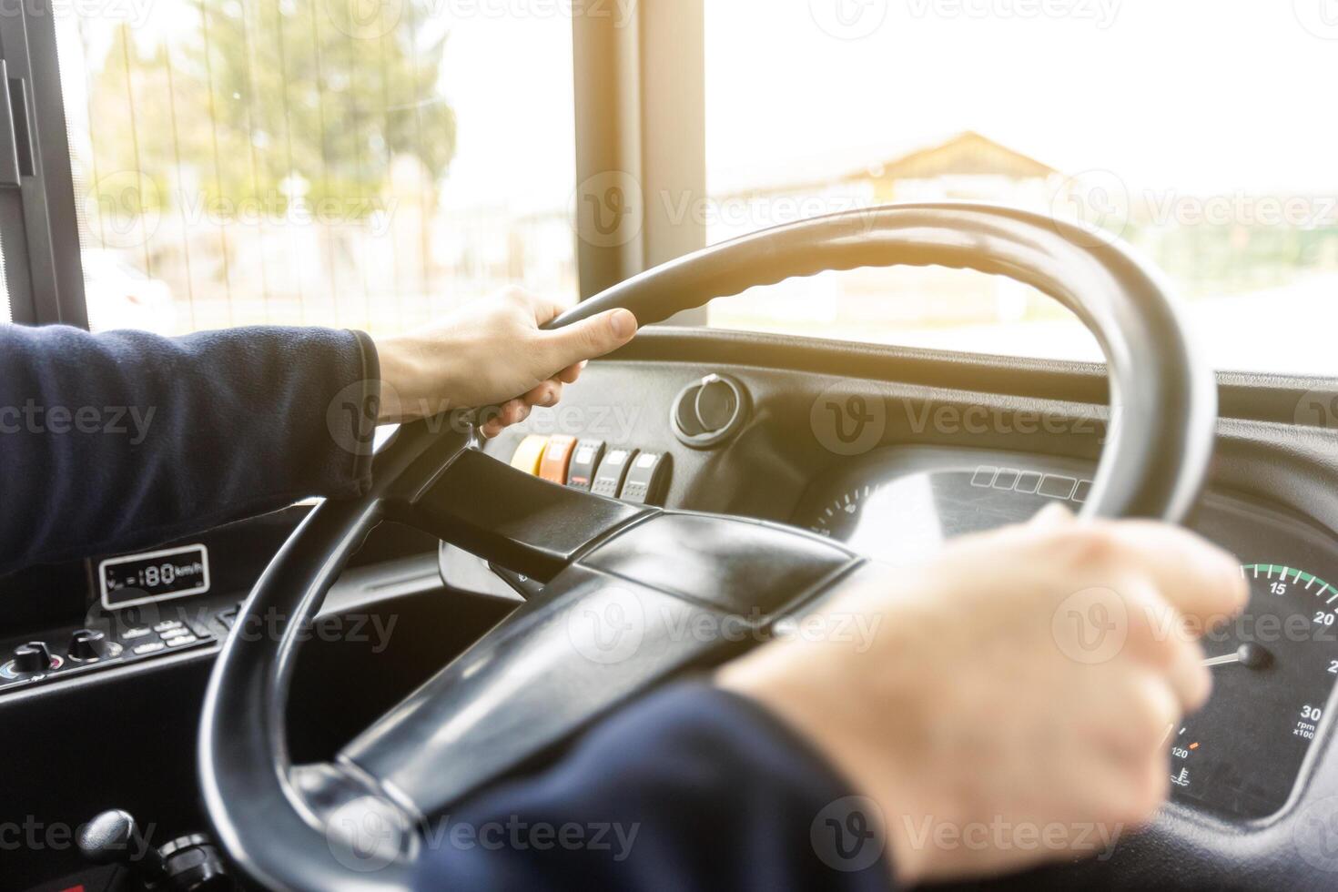 Hands of the driver in a modern bus according to the ride, detail of the bus drivers steering wheel and driving a passenger bus, transportation concept photo