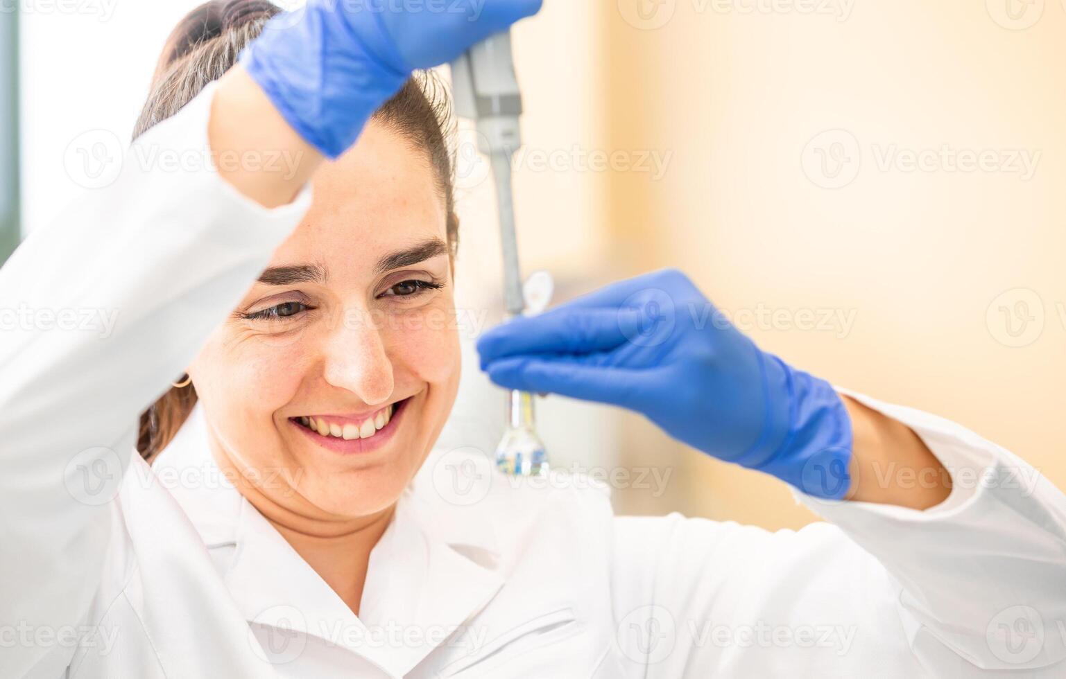 Scientist with dropper dripping liquid into a test tube in scientific laboratory, concept of pharmaceutical environment photo