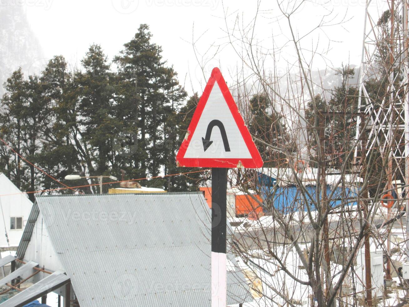 U-Turn Road Signage Board in a mountainous region around a curve mountain photo