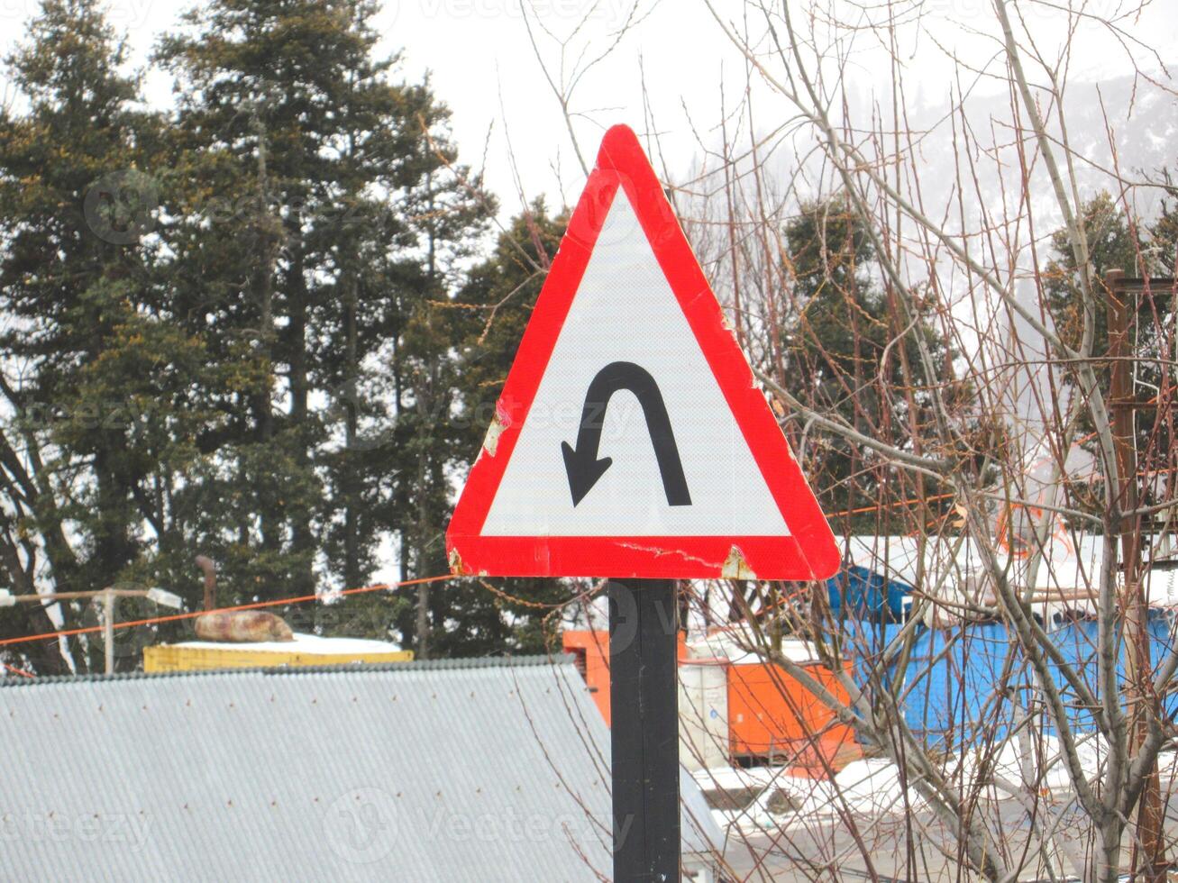 U-Turn Road Signage Board in a mountainous region around a curve mountain photo