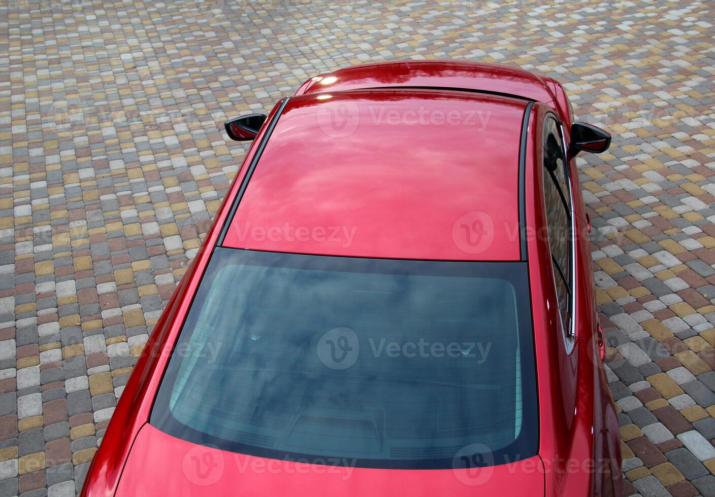 Ongoing View From Above On Red Vehicle Staying On Pavement photo