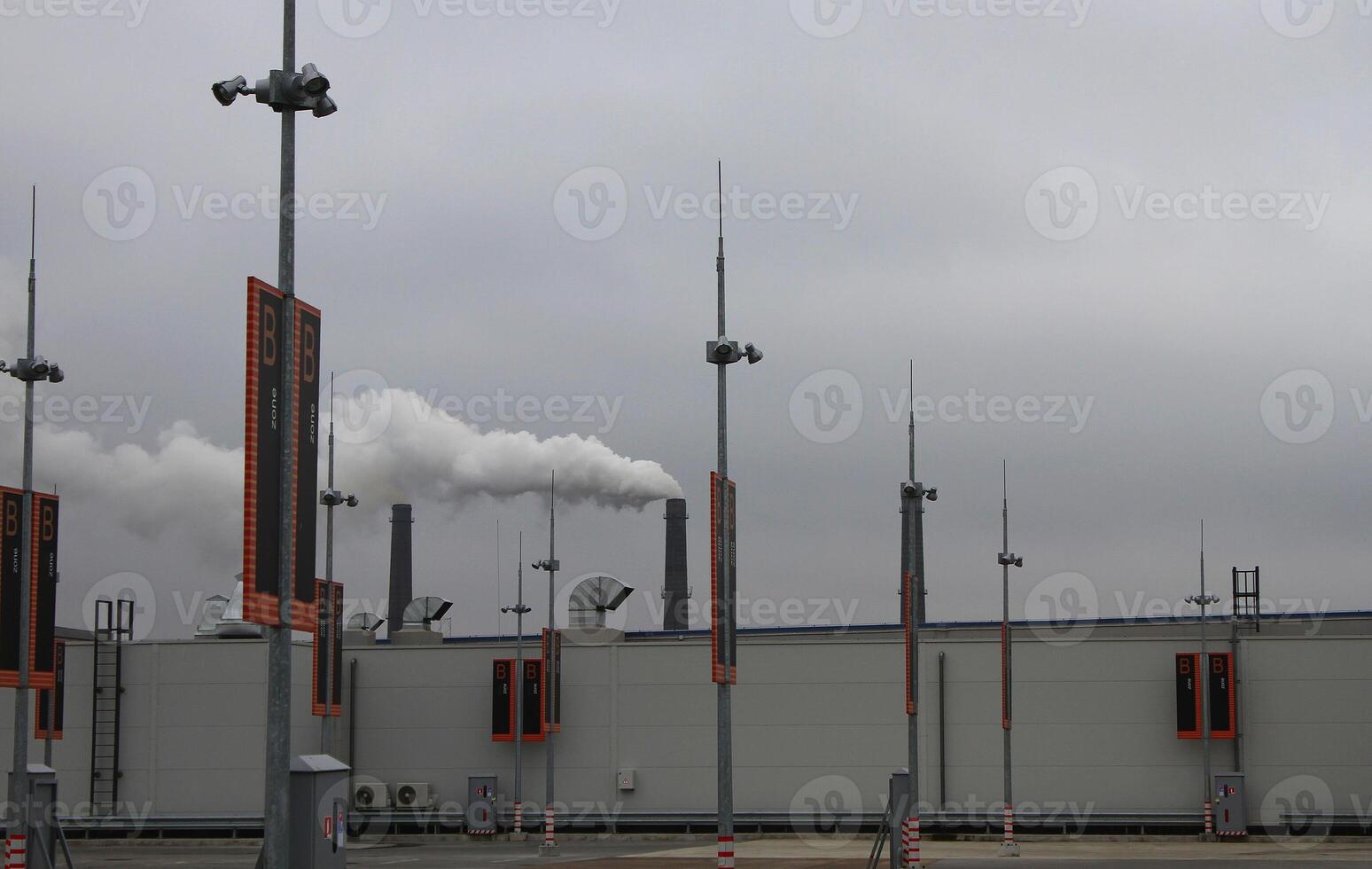 Contaminated Air Over Rooftop Vehicle Park With Smoking Stacks On Background photo