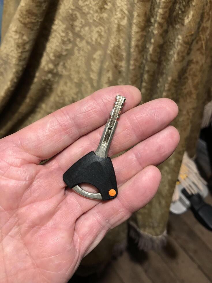 entrance door with a handle, a key inserted into the keyhole photo