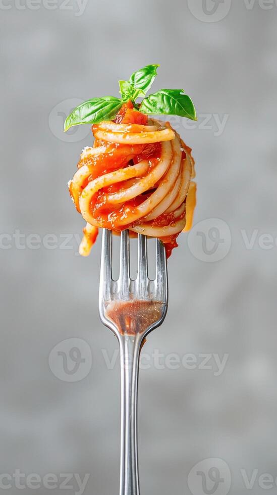 Fork holding spaghetti swirl with rich tomato sauce. Italian cuisine advertising or cooking blogs. photo