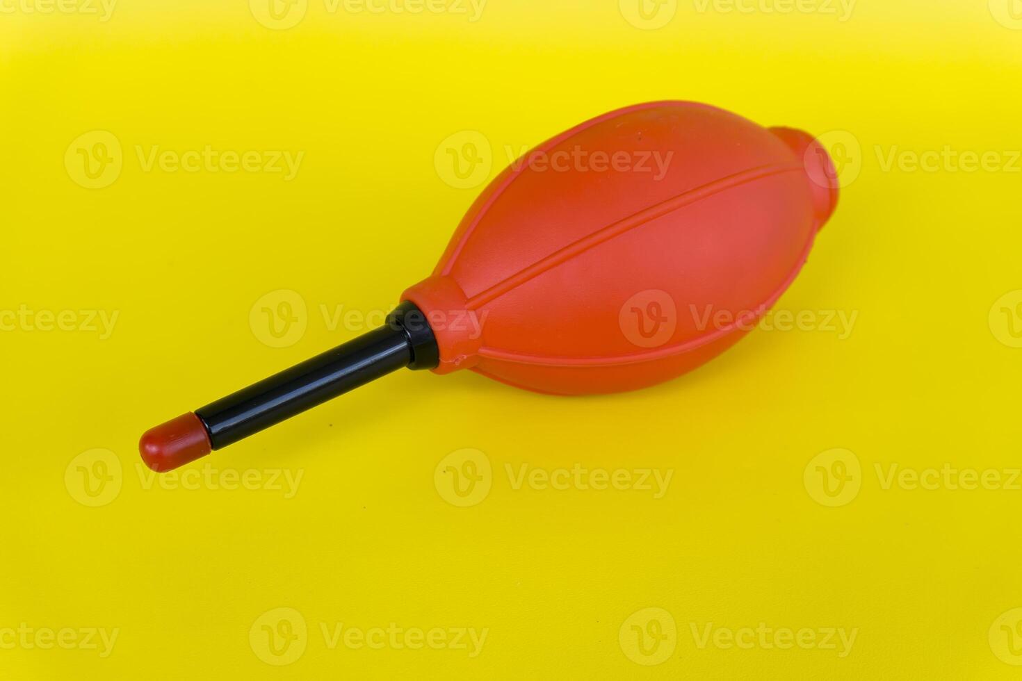 Hand pump red silicone air blower used to clean camera and lens dust photo