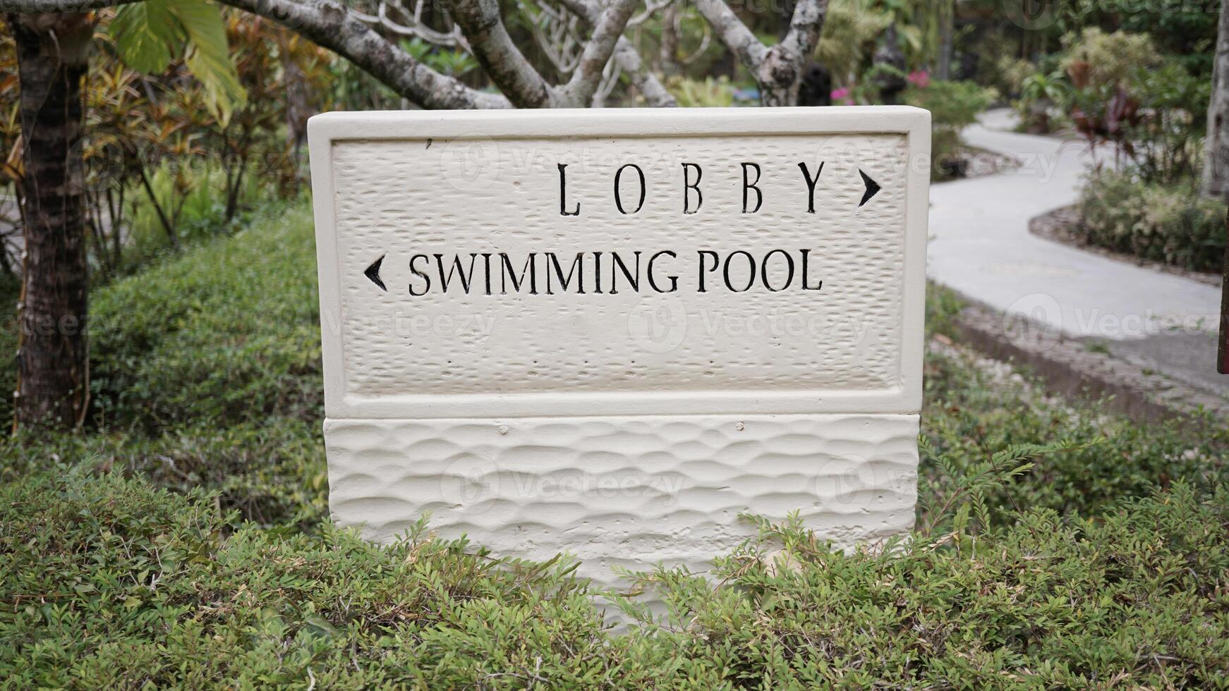 signs with writing to go to the lobby and swimming pool in a hotel photo