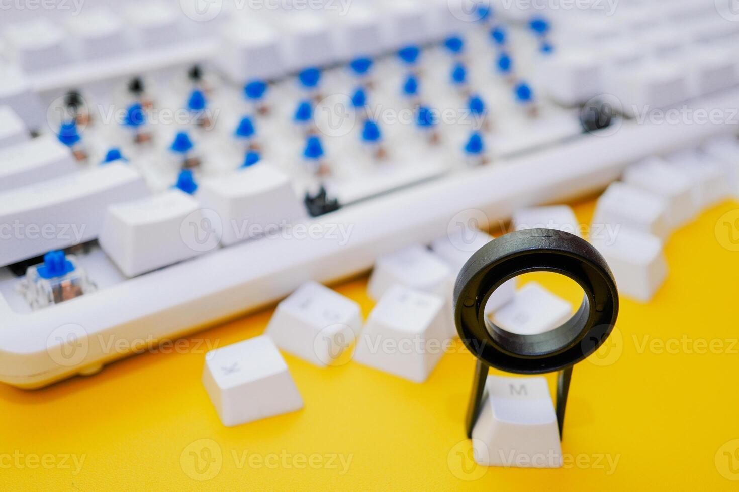Remove mechanical keyboard keycap with tool on yellow background photo