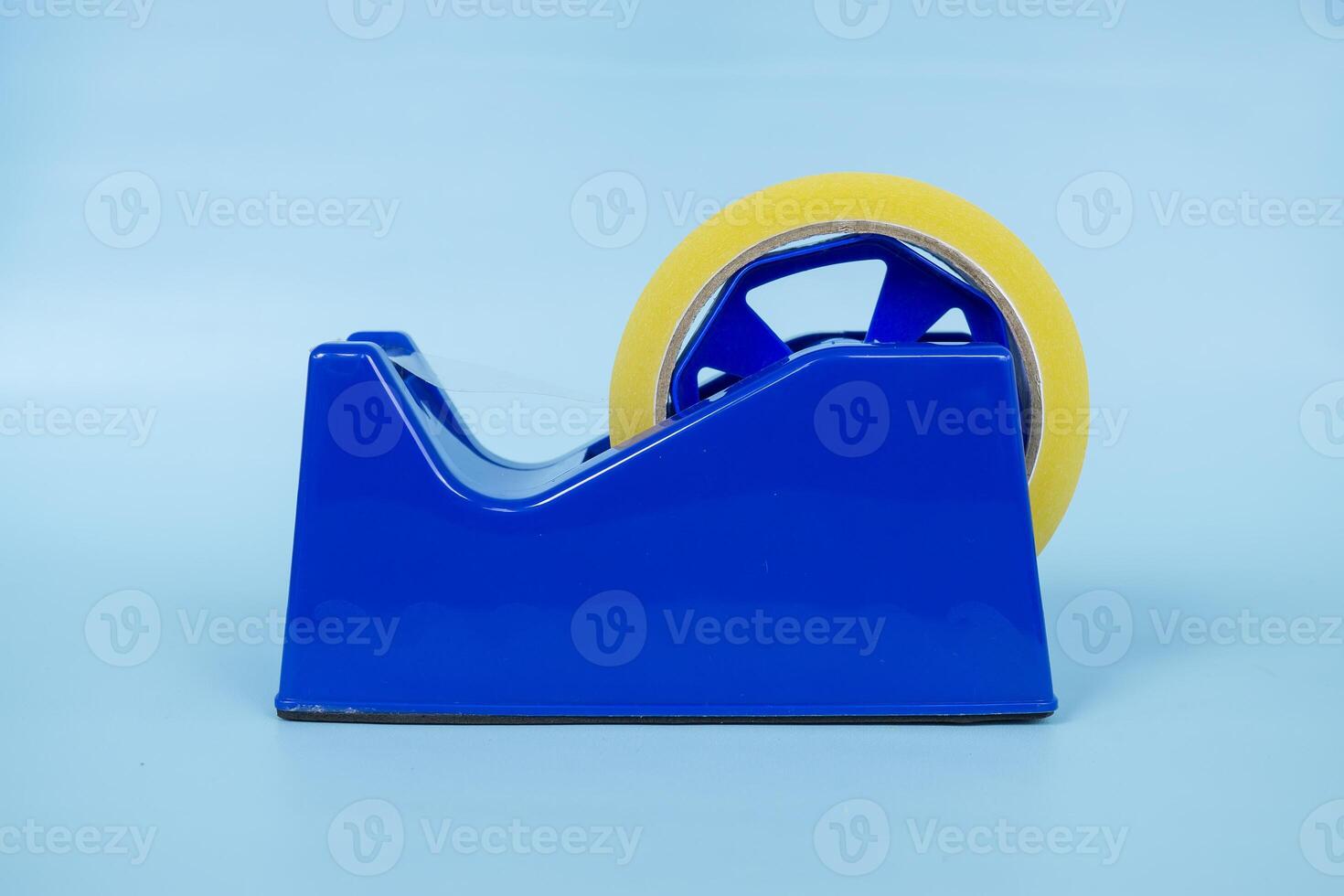 Blue tape dispenser with transparent tape isolated on blue background. photo