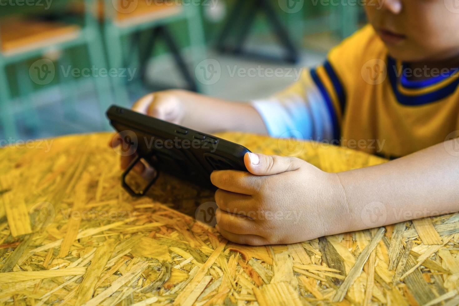 toddler watching cartoons on smartphone with stand phone case photo