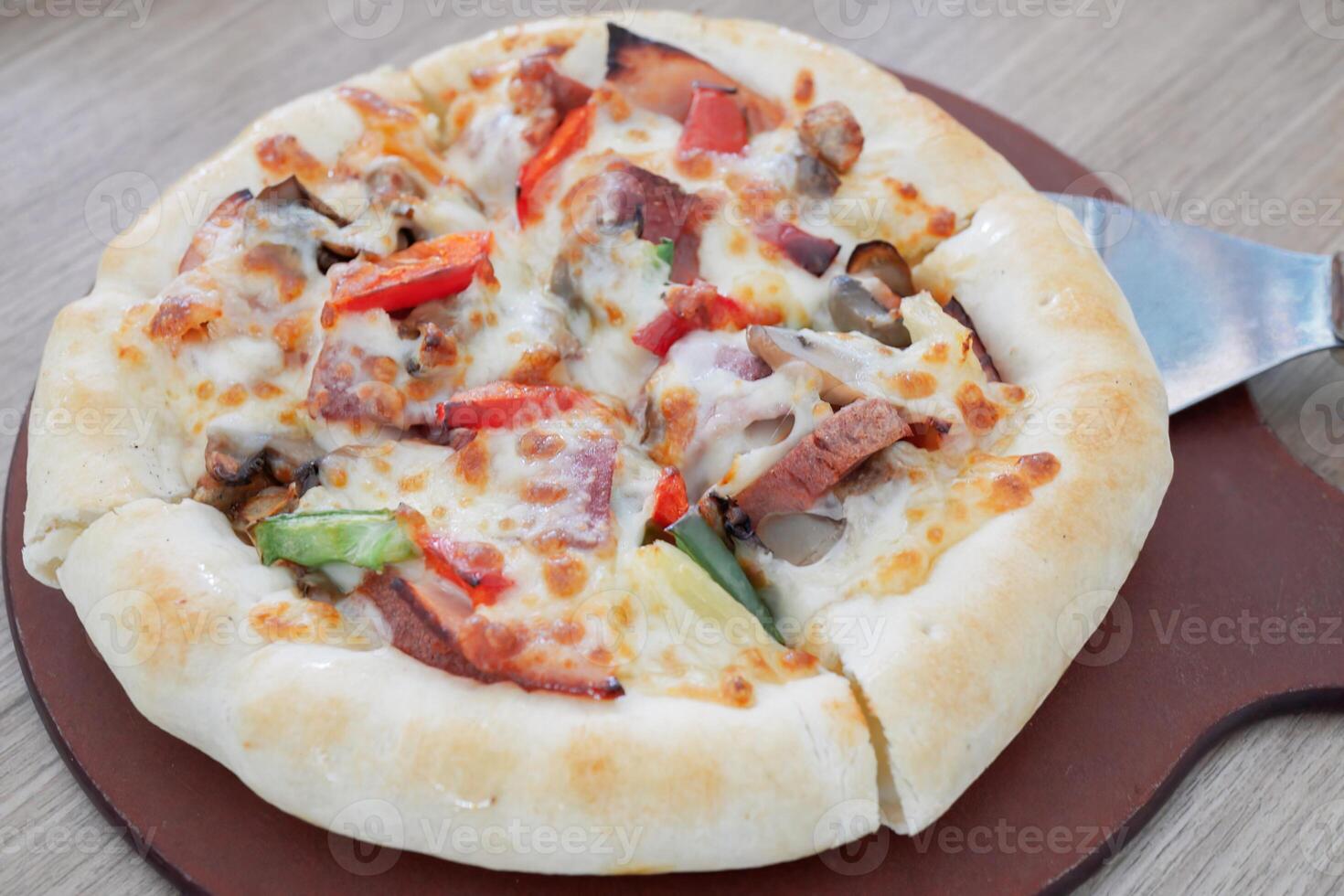 One pan pizza is divided into 4 slices which are smaller than other pizzas photo