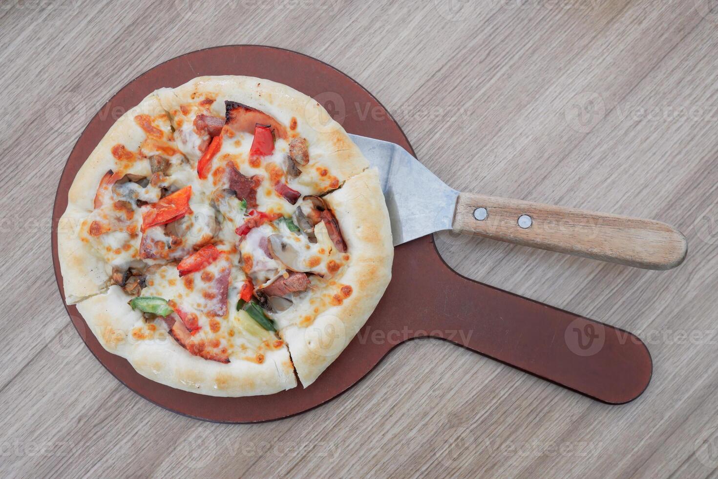 One pan pizza is divided into 4 slices which are smaller than other pizzas photo