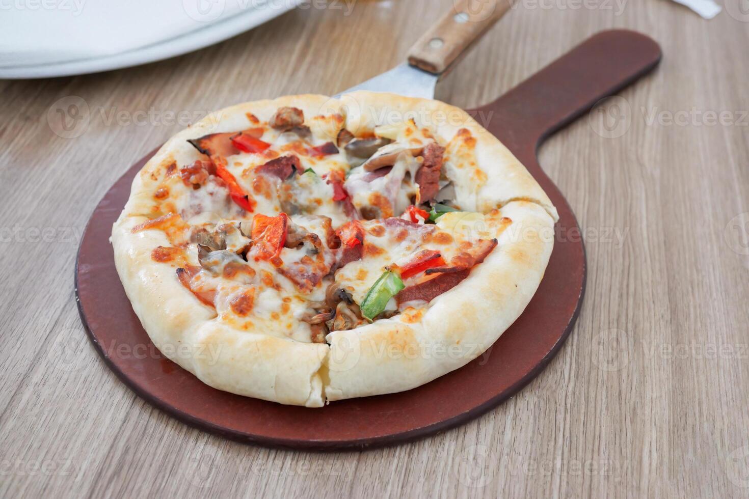 One pan pizza is divided into 4 slices which are smaller than other pizzas photo
