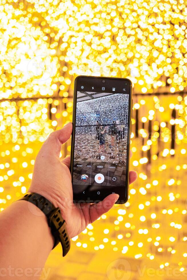 a man's hand holding a smartphone is recording a to immortalize the moment photo