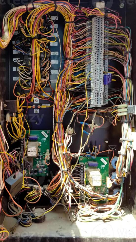 Close-up View of Colorful Electrical Wiring and Circuit Components Inside a Terminal Box in Bright Daylight photo