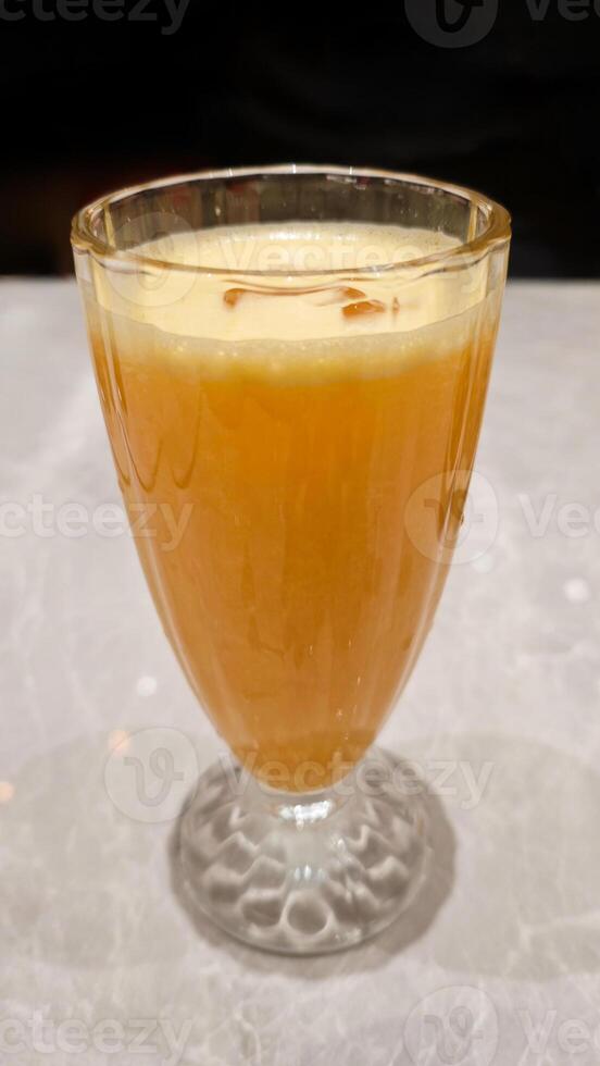 Freshly Squeezed Orange Juice in Elegant Glass on Marble Table with Soft Lighting Background photo