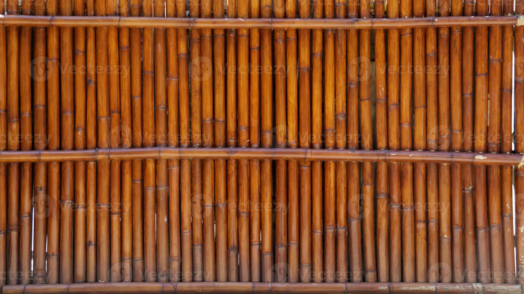 Vertical Bamboo Gate or Wall with Natural Brown Texture in Sunlight Creating an Organic and Rustic Background photo