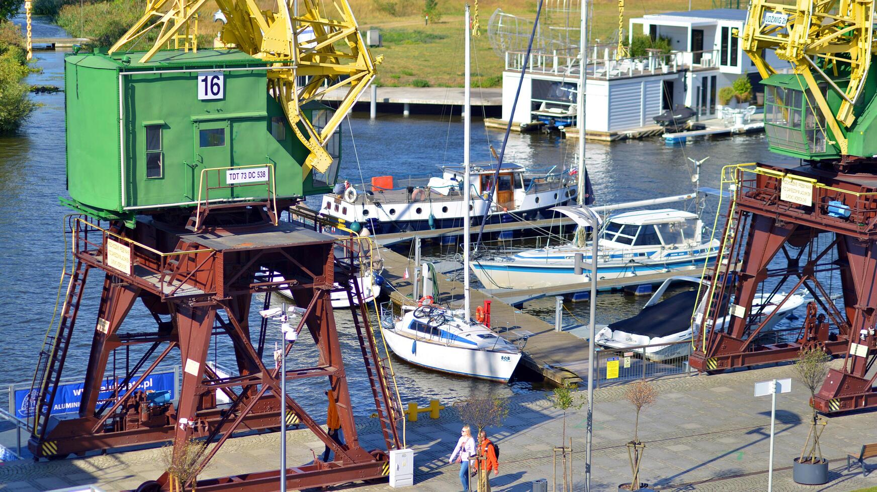 Szczecin, Poland. 14 September 2024. Landscape view and ships on the Odra river and old cranes photo