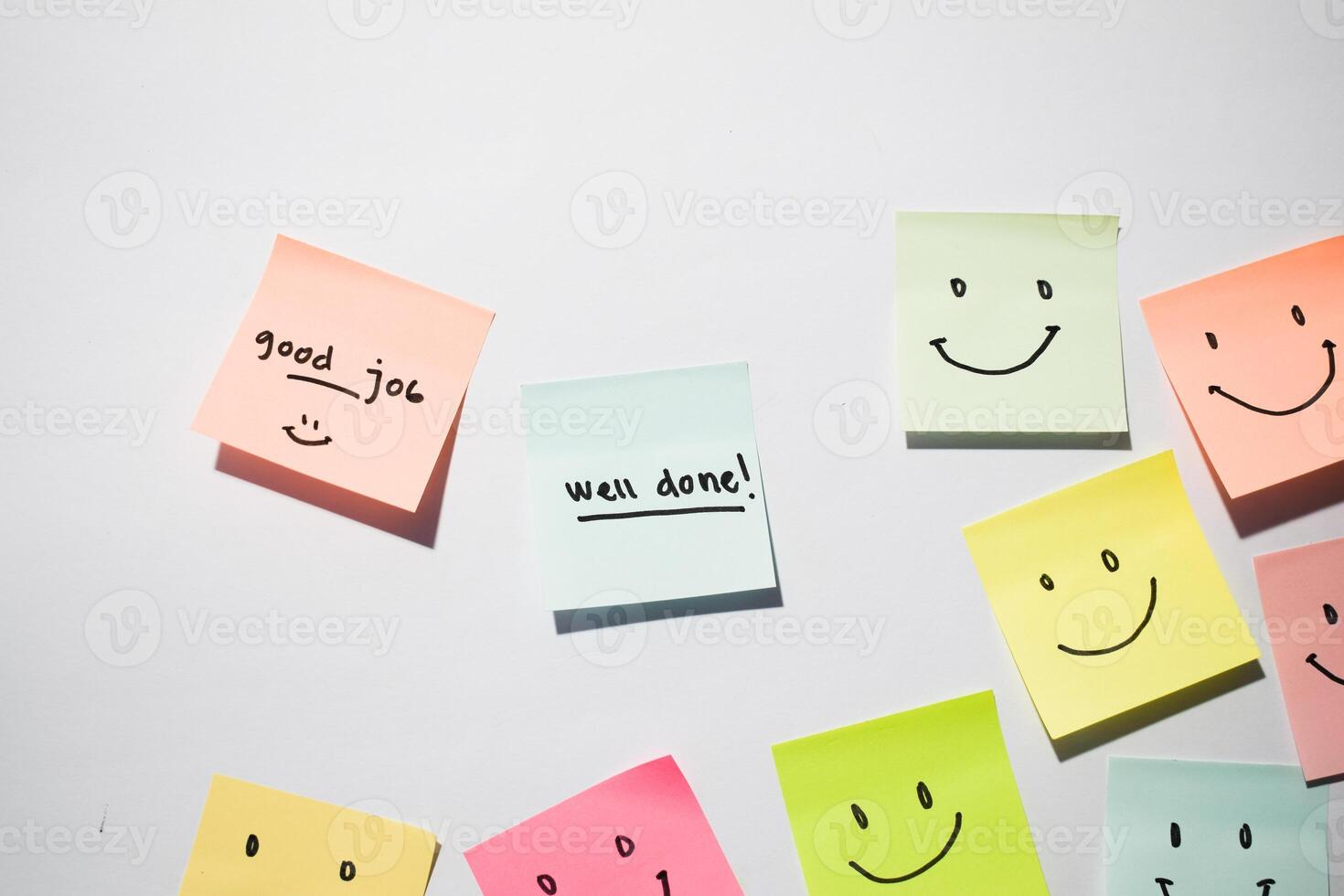 Good Job and well done with smile emoticon on sticky notes. Motivational words for personal development, inspirational handwriting. Isolated on background photo