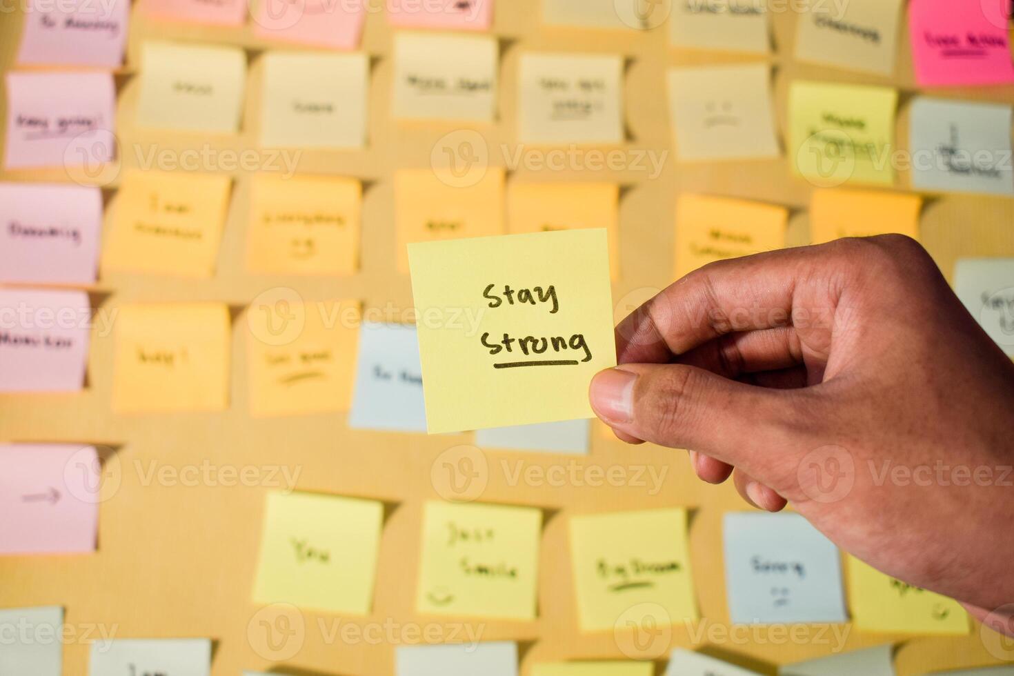 Hand hold sticky notes with words stay strong, Motivational words for personal development, inspirational handwriting. Sticky notes background photo