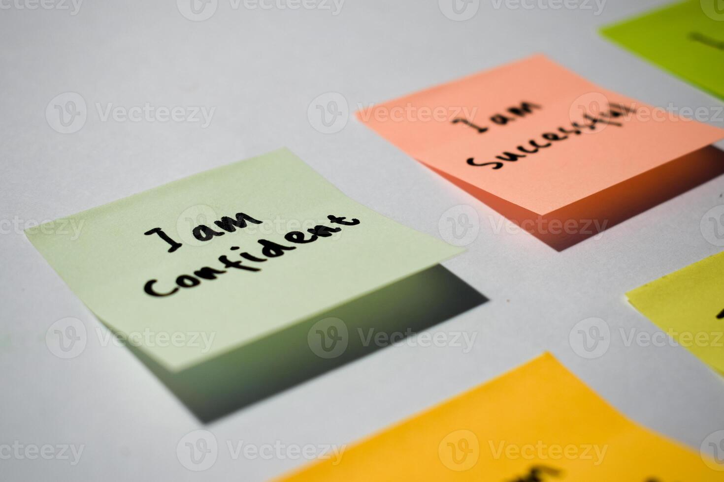 I am confident on sticky notes. Motivational words for personal development, inspirational handwriting. Isolated background photo