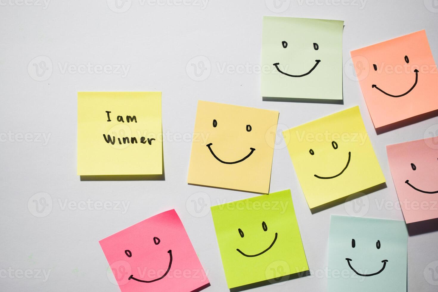 I am winner and smile emoticon on sticky notes. Motivational words for personal development, inspirational handwriting. Isolated on background photo