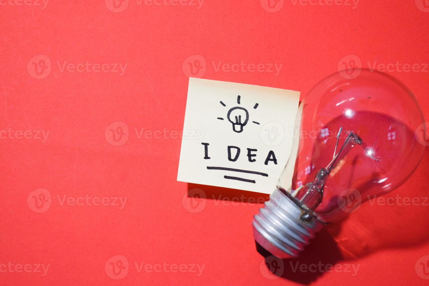 Idea on sticky notes and lightbulb. Isolated red background and copy space photo