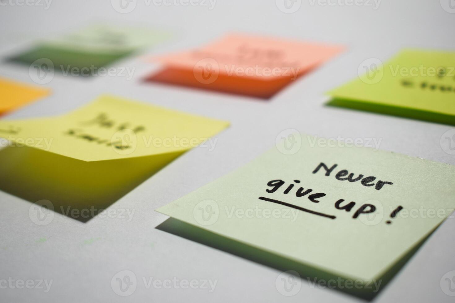 Never give up on sticky notes. Motivational for personal development, inspirational handwriting. Isolated background photo