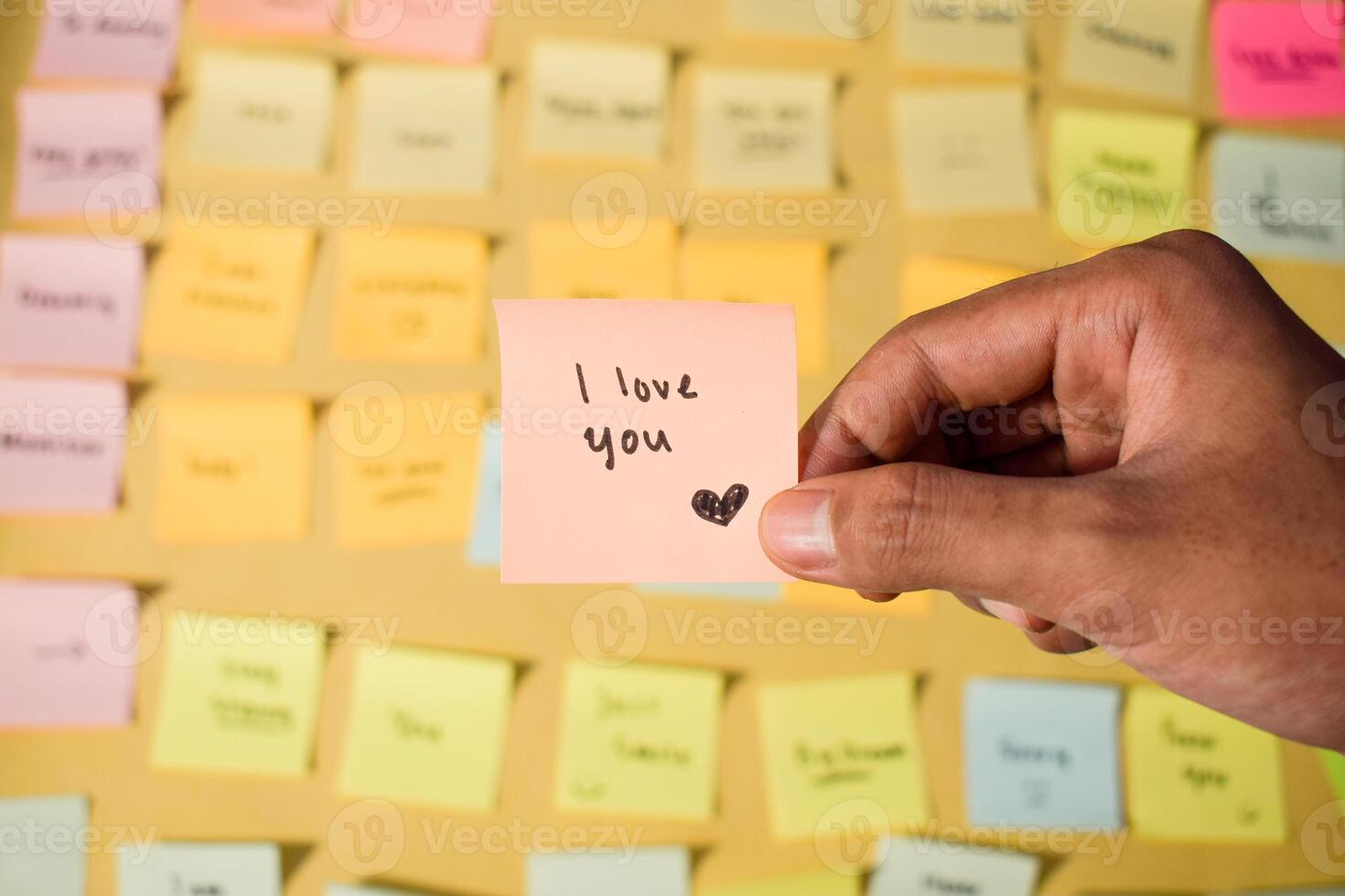 Hand hold sticky notes with words I love you. Motivational words for personal development, inspirational handwriting. Sticky notes background photo