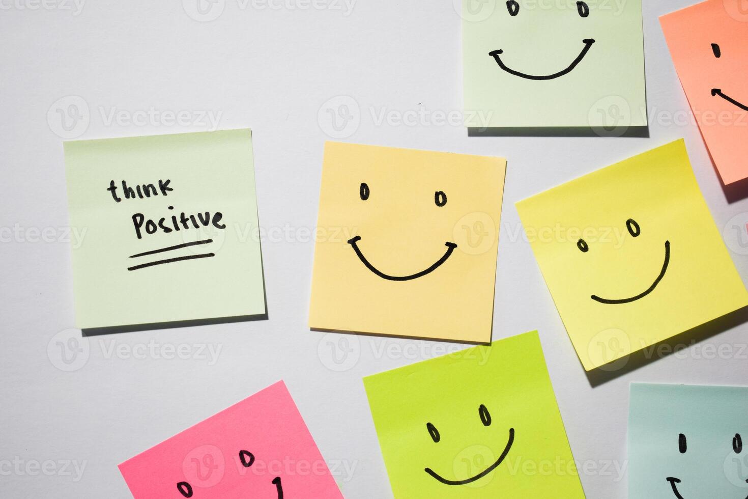Think Positive and smile emoticon on sticky notes. Motivational words for personal development, inspirational handwriting. Isolated on background photo